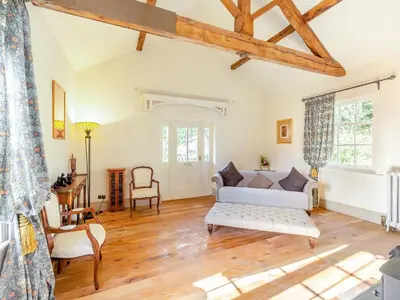 a living room with a couch and a table at Apartment At Llanerchydol Hall in Welshpool