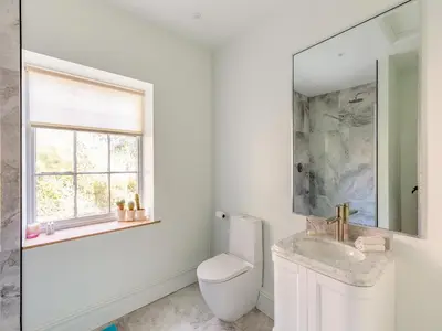 a white bathroom with a toilet and a sink at Apartment At Llanerchydol Hall in Welshpool