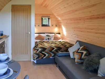 a bedroom with a bed and a couch in a room at Glampio Trysor Merddwr-Ukc5826 in Llangwm