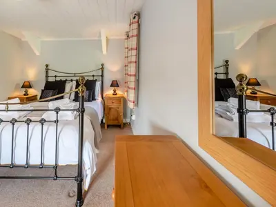 a bedroom with two beds and a mirror at East Llwyn - Uk41756 in Rhyd Owen
