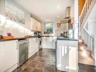 a kitchen with white cabinets and a tile floor at East Llwyn - Uk41756 in Rhyd Owen