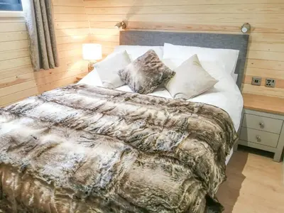 a bedroom with a large bed with white sheets and pillows at Glampio Tryso Garth-Ukc5827 in Llangwm