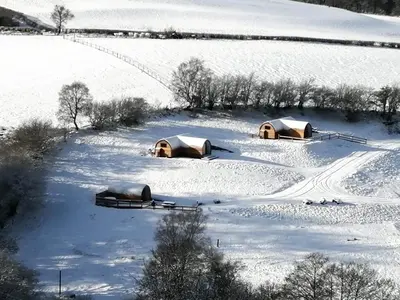 two tents in a field covered in snow at Glampio Tryso Garth-Ukc5827 in Llangwm