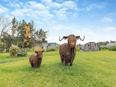 two statues of cows standing in a field at Mayflower - Uk42359 in Saint Harmon