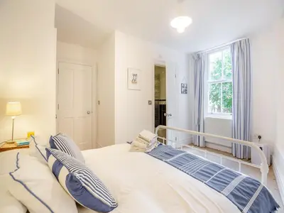 a bedroom with a large bed with blue and white pillows at Apartment 2 in Aberdyfi