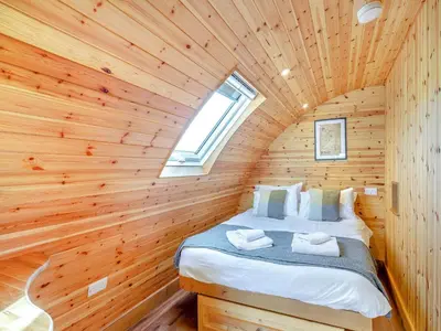 a bedroom in a log cabin with a bed in it at Primrose - Uk42358 in Saint Harmon
