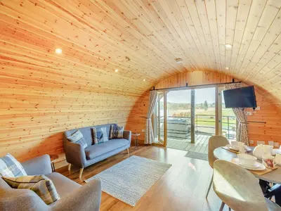 a living room with a wooden ceiling with a table and chairs at Primrose - Uk42358 in Saint Harmon
