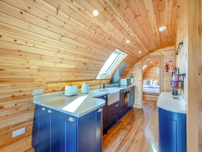 a kitchen with blue cabinets and a wooden ceiling at Primrose - Uk42358 in Saint Harmon