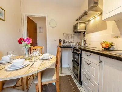a kitchen with a wooden table with chairs and a dining room at Snowdrop in Llanerch-Aeron