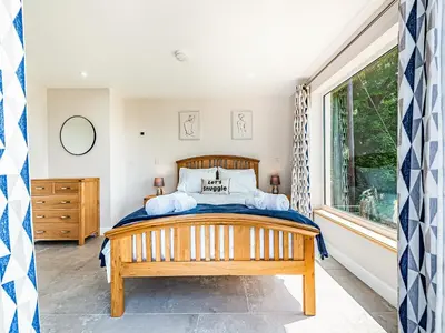 a bedroom with a bed and a window at Llwynblyfyn in Llansawel