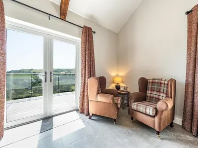a living room with two chairs and a window at Llwynblyfyn in Llansawel