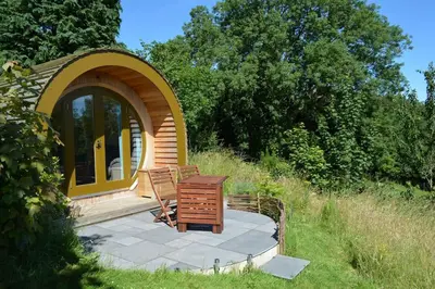 a gazebo with a table and a chair on a patio at Ty Barcud Glamping Pod in Aberystwyth