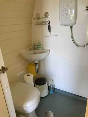 a small bathroom with a toilet and a sink at Ty Barcud Glamping Pod in Aberystwyth