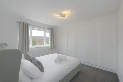 a white bedroom with a bed and a window at MODERN 3 BEDROOM PROPERTY WITH FREE DRIVEWAY PARKING by SHIRE STAYS in Shrewsbury