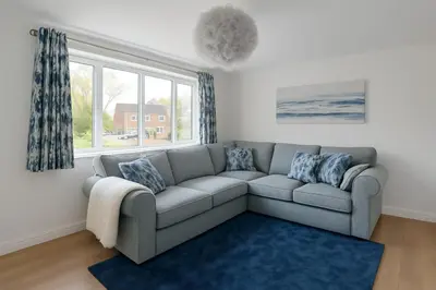 a living room with a couch and a window at MODERN 3 BEDROOM PROPERTY WITH FREE DRIVEWAY PARKING by SHIRE STAYS in Shrewsbury