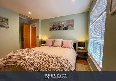a bedroom with a bed with pink pillows and a window at 2 Bedroom Home near Theatre Severn with Parking in Shrewsbury