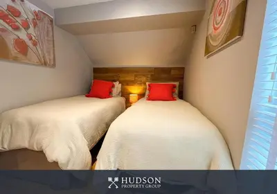 two beds in a small room with red pillows at 2 Bedroom Home near Theatre Severn with Parking in Shrewsbury