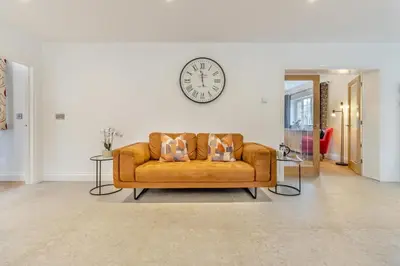 a living room with a couch and a clock on the wall at 4 Bed in Capel Bangor oc-m30145 in Capel Bangor