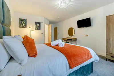 a bedroom with a large white bed with an orange blanket at 4 Bed in Capel Bangor oc-m30145 in Capel Bangor