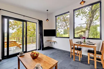 a living room with a table and chairs and windows at 1 Bed in Llanerfyl oc-d30168 in Llanfair Caereinion