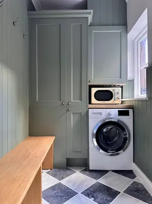 a kitchen with a washing machine and a microwave at Charming Townhouse Retreat in Shrewsbury