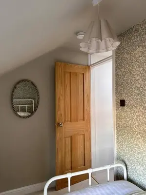a bedroom with a bed and a wooden door at Charming Townhouse Retreat in Shrewsbury