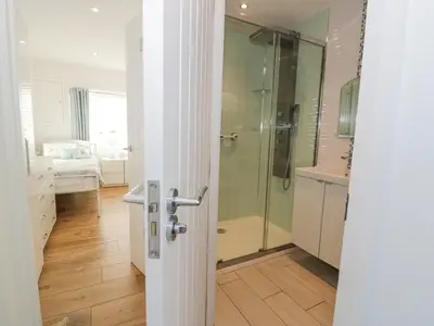 a bathroom with a shower and a glass door at The Gables in Tywyn