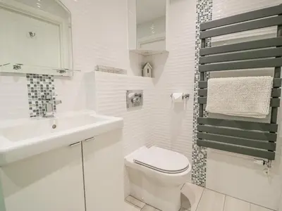 a white bathroom with a toilet and a sink at The Gables in Tywyn