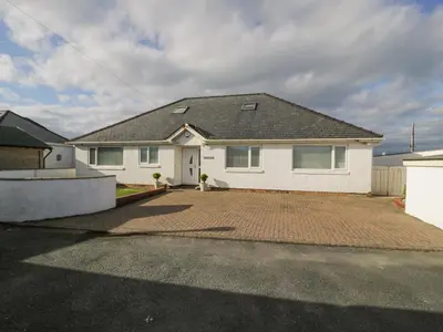 a white house with a brick driveway at The Gables in Tywyn