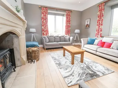 a living room with a couch and a fireplace at Tanat House in Oswestry