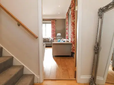 a hallway with a staircase and a living room at Tanat House in Oswestry