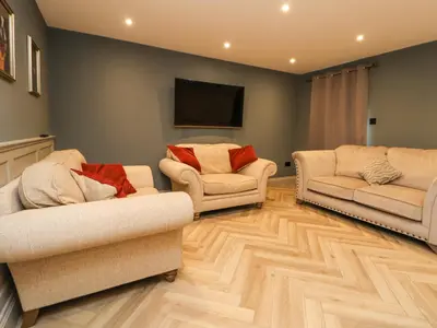 a living room with two couches and a flat screen tv at Tanat House in Oswestry