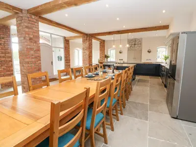 a large dining room with a long wooden table and chairs at Tanat House in Oswestry