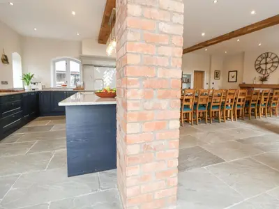a kitchen and dining room with a brick wall at Tanat House in Oswestry