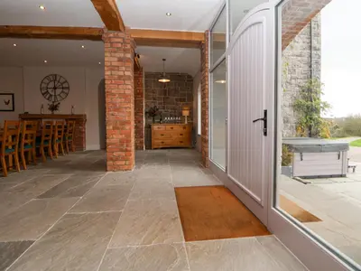 an internal view of a kitchen and dining room with a brick wall at Tanat House in Oswestry