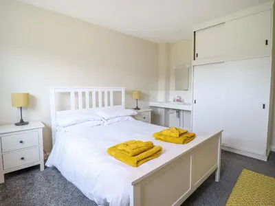 a bedroom with a white bed with yellow towels on it at The Wardens House in Newtown