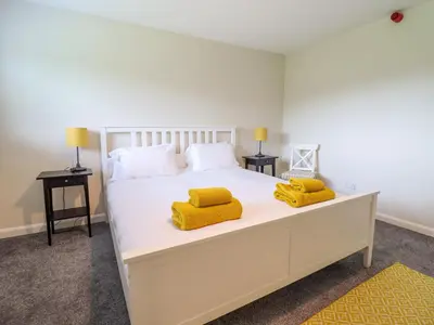 a bedroom with a large white bed with yellow pillows at The Wardens House in Newtown