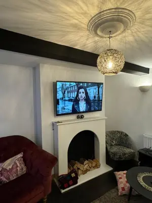 a living room with a tv above a fireplace at 3 bedroom cottage Brecon sleeps 4 in Brecon