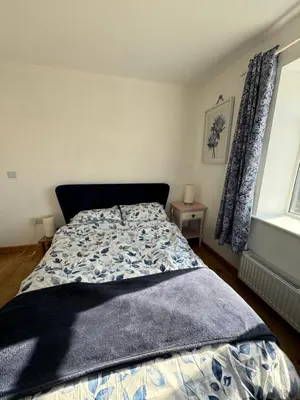 a bedroom with a bed with a blue comforter at 3 bedroom cottage Brecon sleeps 4 in Brecon