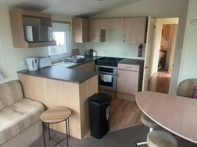 a small kitchen with a counter and a table at Gorgeous Sea Viev 3 Bedroom Delta Bromley Deluxe in Aberystwyth