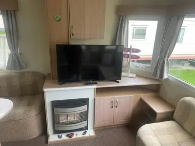 a flat screen tv sitting on a stand in a living room at Gorgeous Sea Viev 3 Bedroom Delta Bromley Deluxe in Aberystwyth
