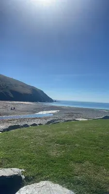 a beach with green grass and the ocean at Gorgeous Sea Viev 3 Bedroom Delta Bromley Deluxe in Aberystwyth