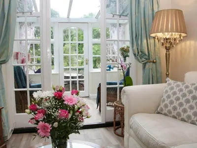 a living room with a couch and a vase of flowers at Troutbeck Cottage in Ludlow