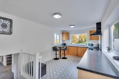 a kitchen with a counter and a table in it at Trinity Cottage in Welshpool
