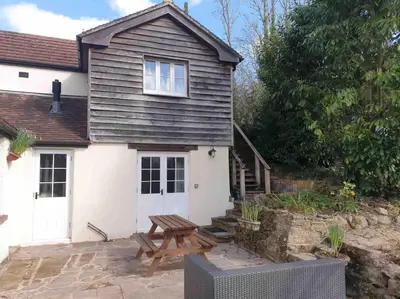 a detached cottage with a picnic table and a bench at Craig Fach Coach House in Builth Wells