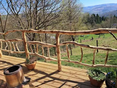 a wooden deck with potted plants and a view of a field at Hilltop Train Carriage with a View in Machynlleth