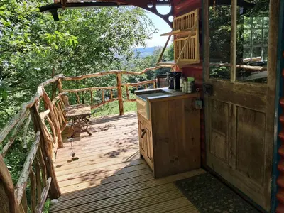 an open door to a deck with a kitchen on it at Hilltop Train Carriage with a View in Machynlleth
