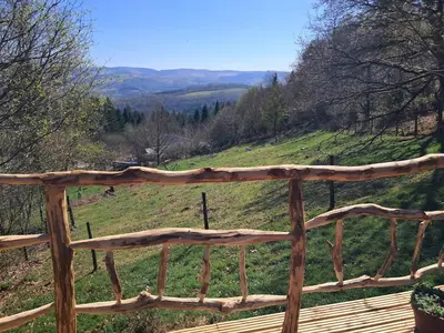 a wooden fence with a view of a hill at Hilltop Train Carriage with a View in Machynlleth
