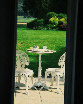 a table with two chairs and a table with cups on it at The Hornbill at Home Farm Shropshire in Shrewsbury