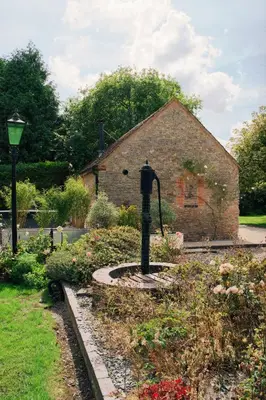 a garden in front of a brick building at The Hornbill at Home Farm Shropshire in Shrewsbury
